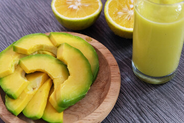 Avocado smoothie or juice with some avocado slice as the background.