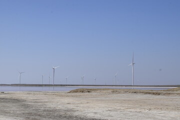 Windmills on the Lemurian salt lake against the blue sky.