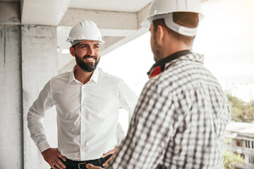 Entrepreneur speaking with worker on construction site
