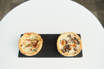 Tart with mushrooms and cheese on a white plate. Close-up