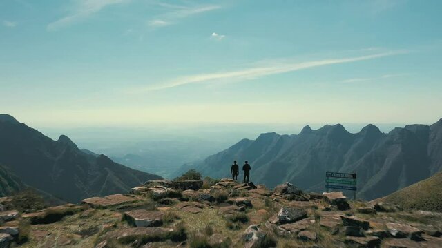 Aerial view of two hikers on top of a plateau brazilian canyon with mountains and horizon, Canion Da Ronda, Santa Catarina, Brazil