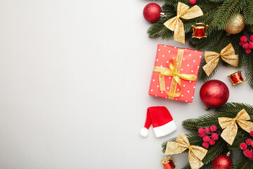 Christmas gift box and decorations on grey table.