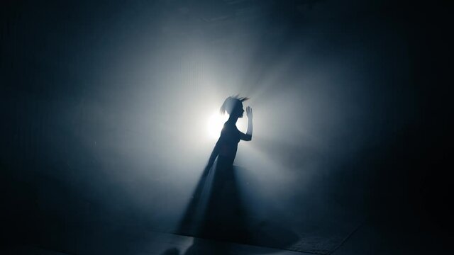 Fit woman training. Backlighted woman silhouette doing reverse lunge exercises.Side view,slow motion