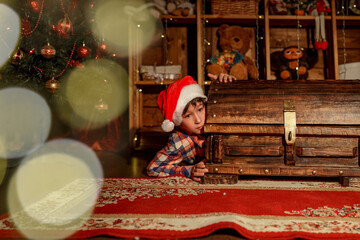 Obraz na płótnie Canvas The boy with presents, gifts near Christmas tree. Happy New Year and Merry Christmas.