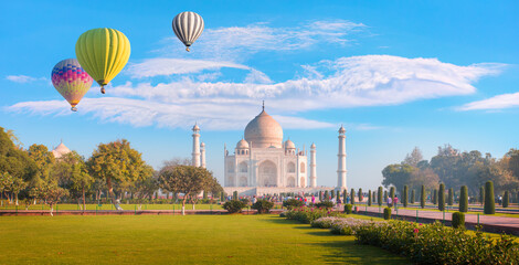 Hot air balloon flying over spectacular Taj Mahal, strange clouds in the background - Agra, India