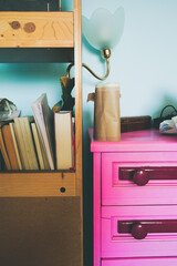 Detail of home decor with a bookcase and a colorful furniture