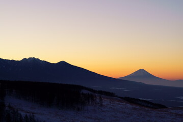 The silhouette of Mt. Fuji that emerges in the orange sunrise sky