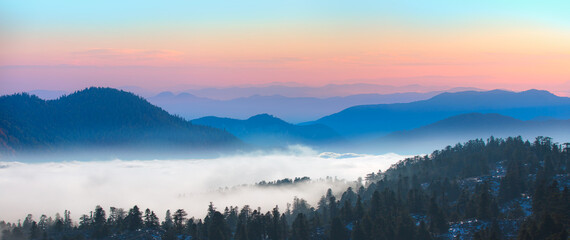 Fototapeta na wymiar Beautiful landscape with cascade blue mountains at the morning - View of wilderness mountains during foggy weather