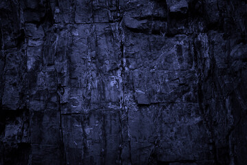 Toned stone texture. Black blue rock background. Detail. Dark grunge background with light effect.