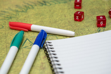 Markers to prepare the game, notebook and dice ready to start playing on the battlefield of...