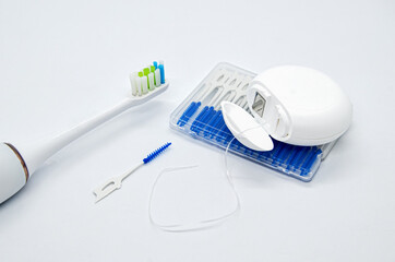 Oral Care: electric toothbrush, dental floss and brushes for interdental spaces on white background