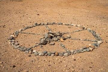 A wheel of samsara made of stones on the ground.