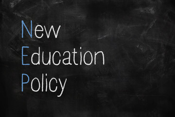 New education policy postponed written with white and red chalk on blackboard