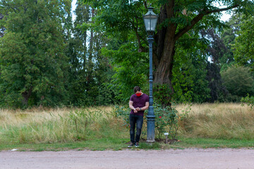 Obraz premium Mann mit rote Maske, wartet im Park