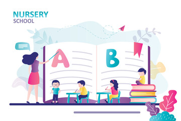 Teacher explaining alphabet to children. Concept of nursery school. Kids sit at desk and gain new knowledge