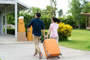 Young Asian husband and wife couple carrying luggage in new home. Moving Day concept.