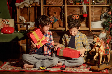 Christmas Children Open Present Gift, Happy Baby Boy looking to the gifts, Kid sitting near the Xmas Tree