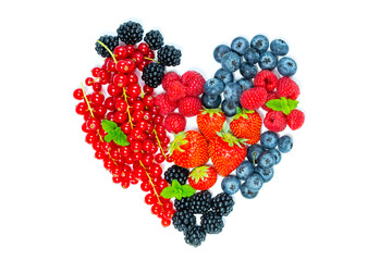 Mix of ripe berries laid out in a shape of heart isolated on the white background. Top view. Flat lay made of strawberries, blueberries, raspberries, blackberries, red currants.