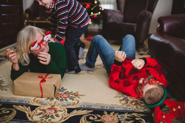 Grandmother and two children are spending time together in the living room. They are having fun for...