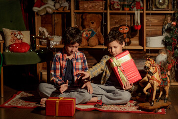 Christmas Children Open Present Gift, Happy Baby Boy looking to the gifts, Kid sitting near the Xmas Tree