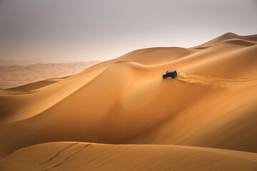 car driving in Rub al Khali Desert at the Empty Quarter, in Abu Dhabi, UAE