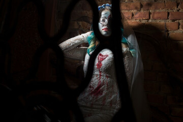 Halloween concept of bride in white dress and bloody makeup, mystical devil bride