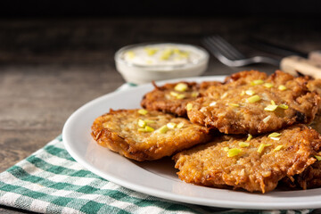 Traditional Jewish latkes or potato pancakes on wooden table