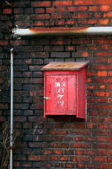 レンガの壁に設置した消火バケツ