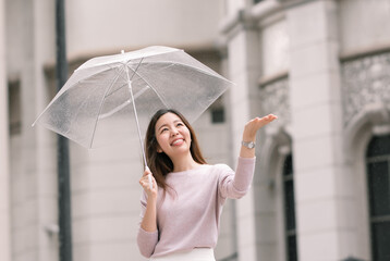 Asian woman holding umbrella in raining season