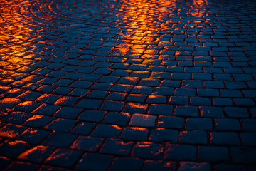 city lights reflected in wet cobblestone at night