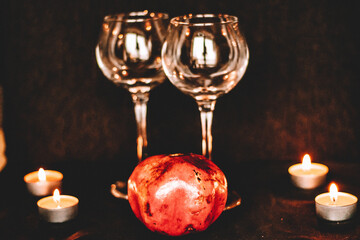 wine glasses with lighted candles, pomegranate