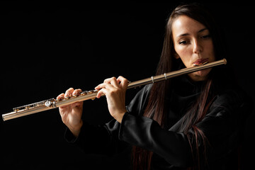 A beautiful young woman play a golden flute - obrazy, fototapety, plakaty