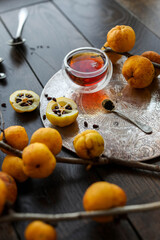 Autumn tea with quince. Small yellow quince fruits on the branches on a wooden table. Flat lay. Japanese.