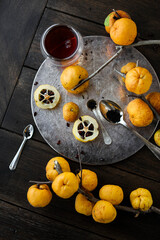 Autumn tea with quince. Small yellow quince fruits on the branches on a wooden table. Flat lay. Japanese.