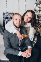 Cute young family husband and wife at the Christmas tree