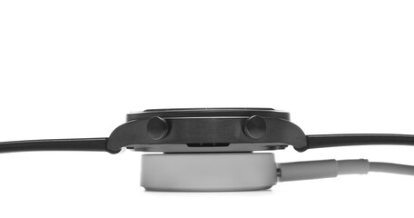 New black smart watch on wireless charger isolated on white background