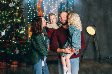 Young family with two children at the Christmas tree