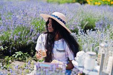 Beautiful indian girl in sitting in purple lavender field.