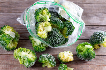 Fresh frozen broccoli in a plastic bag on wooden table
