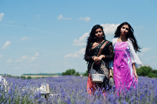 Two Beautiful Indian Girsl Wear Saree India Traditional Dress In Purple Lavender Field.