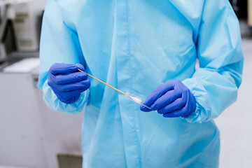 Medical scientist in PPE suit uniform holding  swab coronavirus test in laboratory