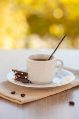 coffee mug in a cafe on a wooden table against the background of autumn leaves. Autumn mood.
