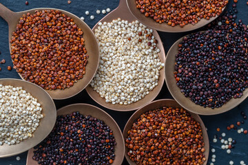Quinoa seeds in spoon and on background, close up, top view