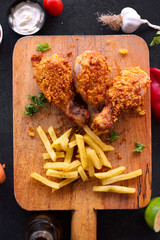 
Delicious homemade crispy fried chicken with sauces on black marble background