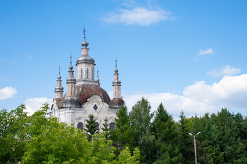 old church against the backdrop of a beautiful sky and green trees