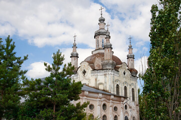 old church against the backdrop of a beautiful sky and green trees