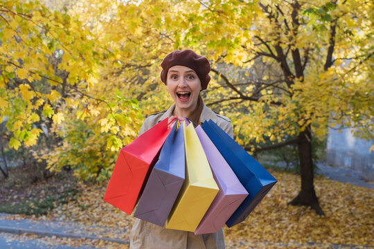 Joyful girl with purchases in hand. Good shopping. Fall discounts.