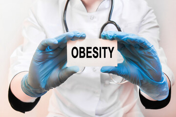 Doctor holding a card with text OBESITY, medical concept