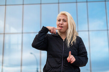 Emotional deaf and dumb woman talking sign language outdoors.