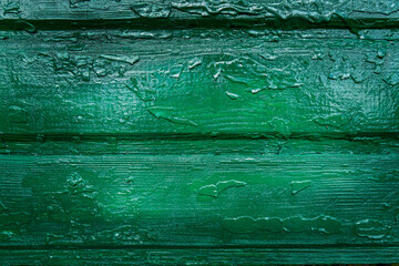 Wooden boards with traces of old paint are painted in a bright green color. Texture, wood, wall, it can be used as background.